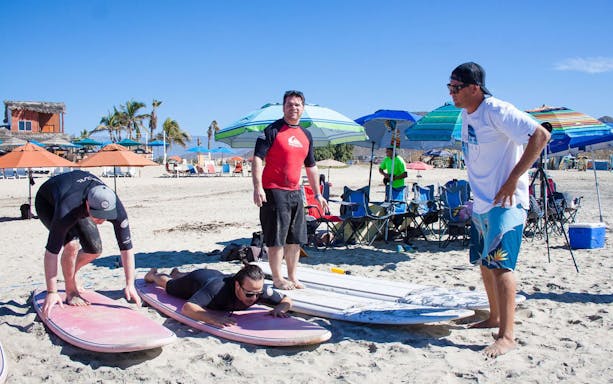 Surf instructor guiding students on Cerritos Beach, Baja California Sur.