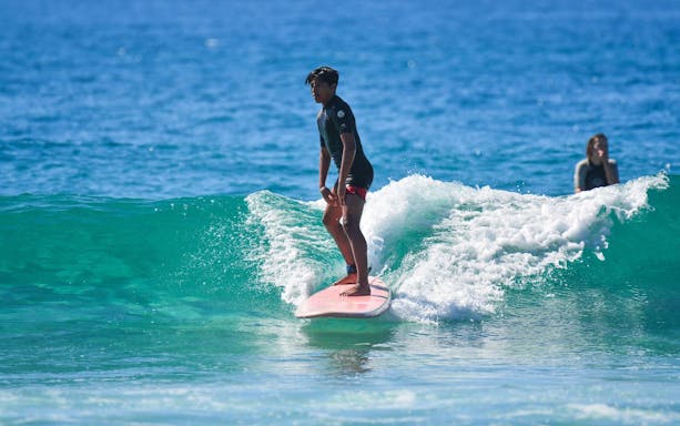 Surfer riding a wave during a private lesson at Cerritos Beach.