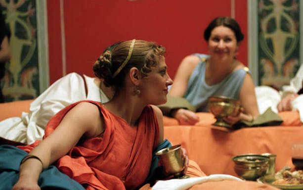 Guests in Roman attire enjoying a banquet at Roma World.