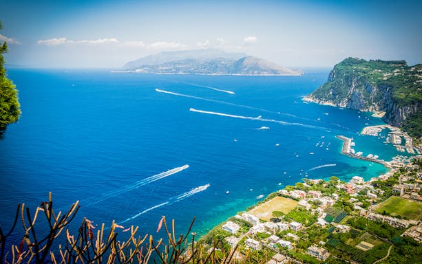 Capri coastline view with boats in the sea, seen from Anacapri, Italy.