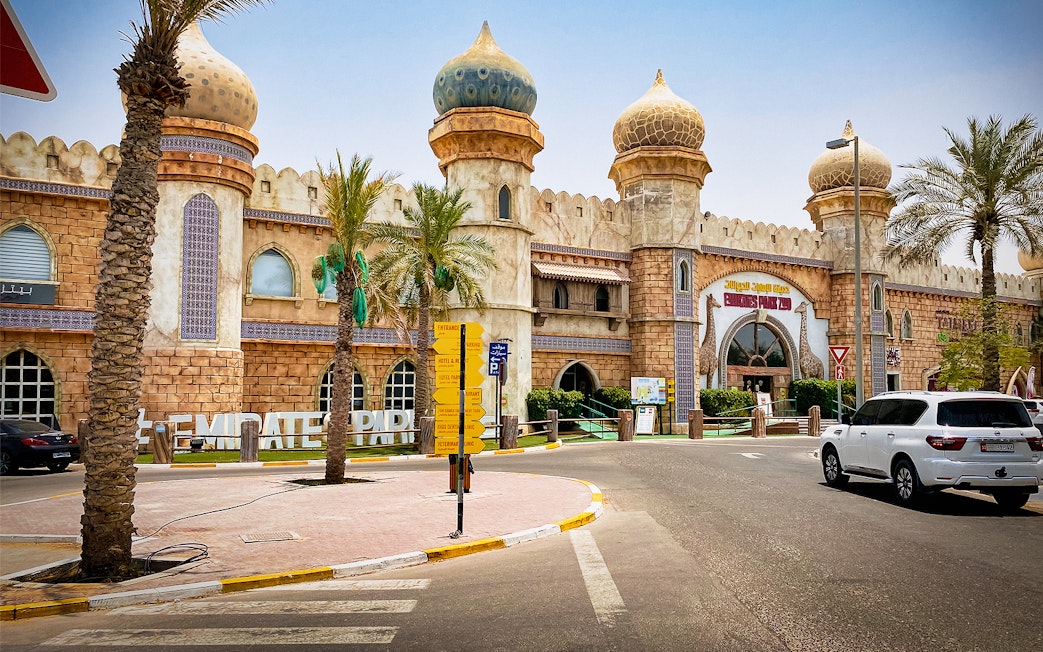 Entrance of Emirates Park Zoo with domed architecture and palm trees in Abu Dhabi.