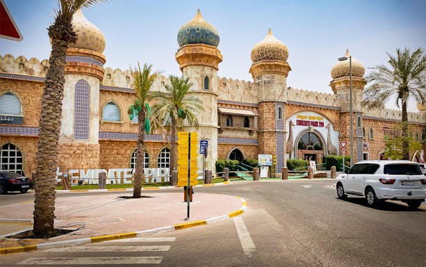 Entrance of Emirates Park Zoo with domed architecture and palm trees in Abu Dhabi.
