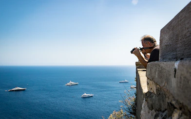 Photographer capturing yachts on the sea near Capri and Anacapri, Italy.