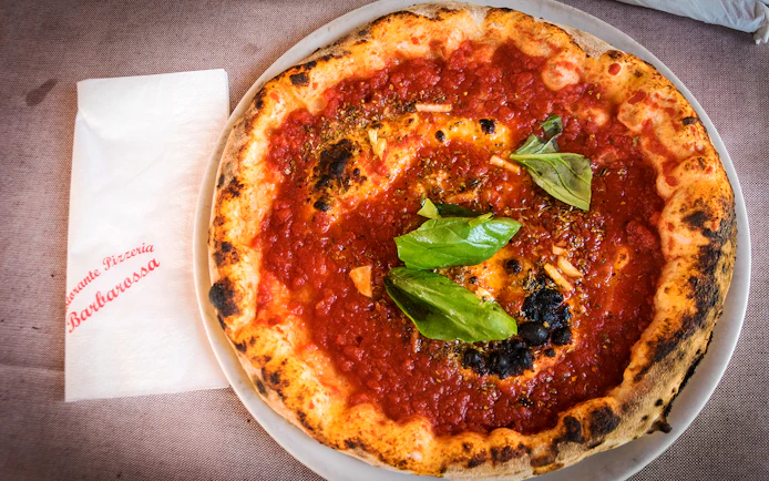 Pizza with tomato sauce and basil served at a restaurant in Capri, Italy.