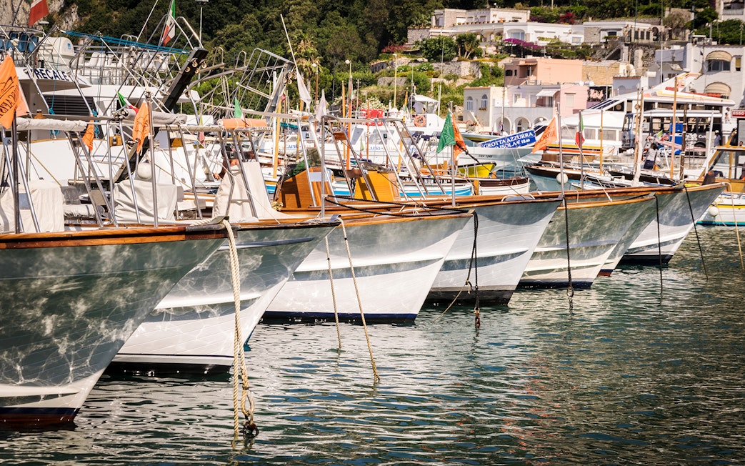 Boats docked at Capri harbor, Italy, for tours to Anacapri and Blue Grotto from Sorrento.