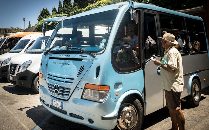 Tourists boarding a bus for Capri and Anacapri tour from Sorrento meeting point.