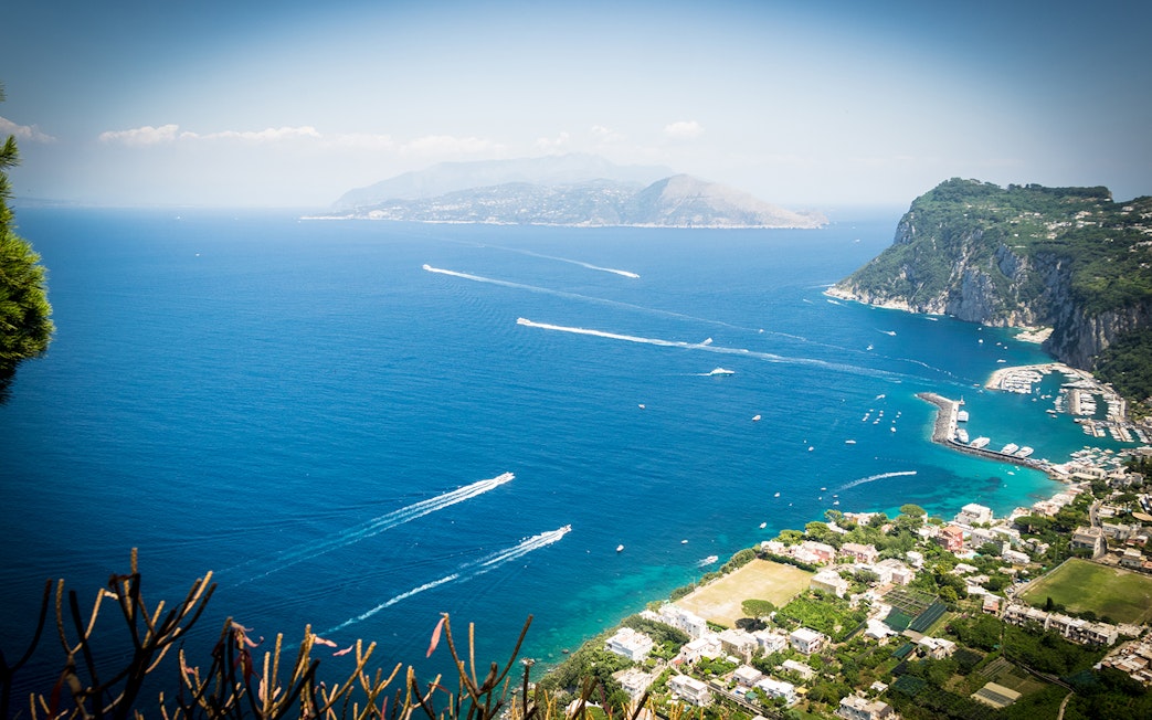 Aerial view of Capri Island coastline with boats and marina, Italy.