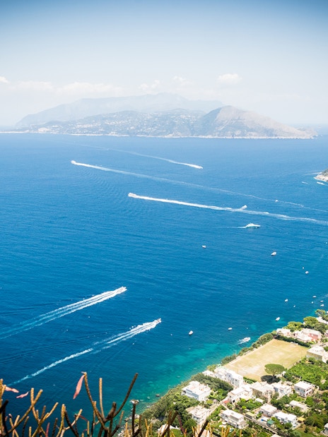 Aerial view of Capri Island coastline with boats and marina, Italy.