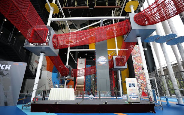Adventure HQ indoor climbing and obstacle course with red net tunnels.
