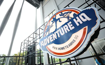 Adventure HQ entrance sign with website URL, promoting All-Access Pass.