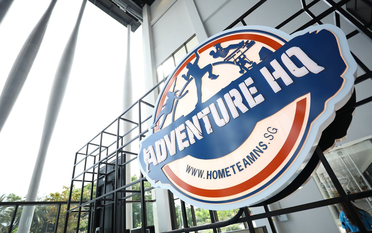 Adventure HQ entrance sign with website URL, promoting All-Access Pass.