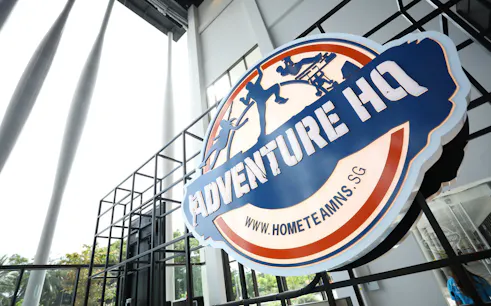 Adventure HQ entrance sign with website URL, promoting All-Access Pass.