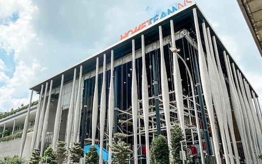 Modern building facade of Adventure HQ with vertical columns and greenery.