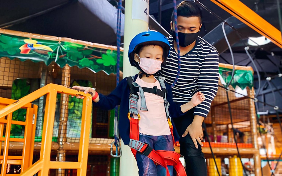 Child in harness at Waka Waka Safari-themed indoor playground.