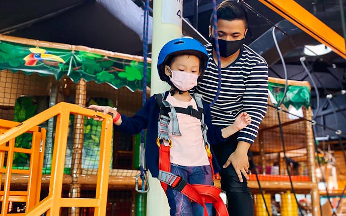 Child in harness at Waka Waka Safari-themed indoor playground.