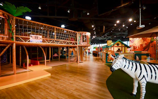 Safari-themed indoor playground with rope bridge and zebra statue at Waka Waka.