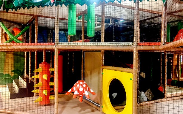 Indoor play structure at Waka Waka Safari-themed playground with climbing nets and slides.