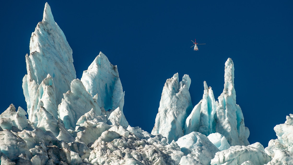 Helicopter flying over ice formations at Franz Josef Glacier.