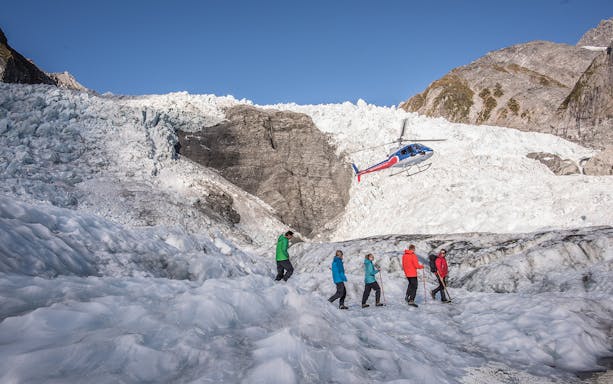 Helicopter and hikers on Franz Josef Glacier, New Zealand.