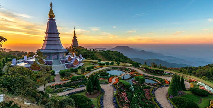 Twin pagodas at Doi Inthanon National Park during sunset, surrounded by gardens and mountain views.