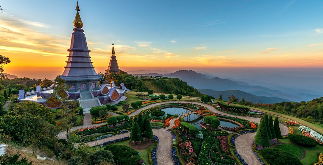 Twin pagodas at Doi Inthanon National Park during sunset, surrounded by gardens and mountain views.