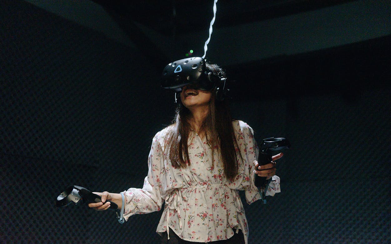 Person enjoying a VR escape room experience with headset and controllers.