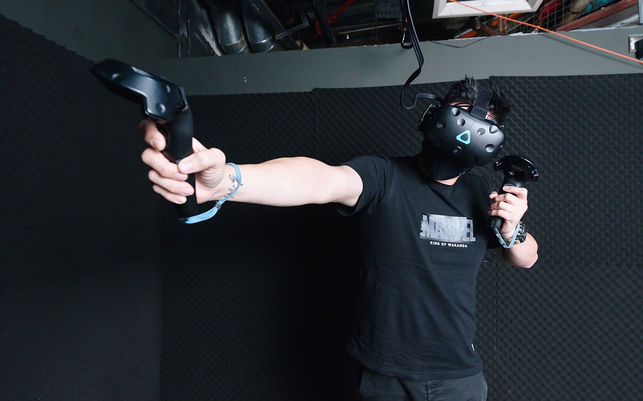 Person using VR headset and controllers in a virtual escape room adventure.