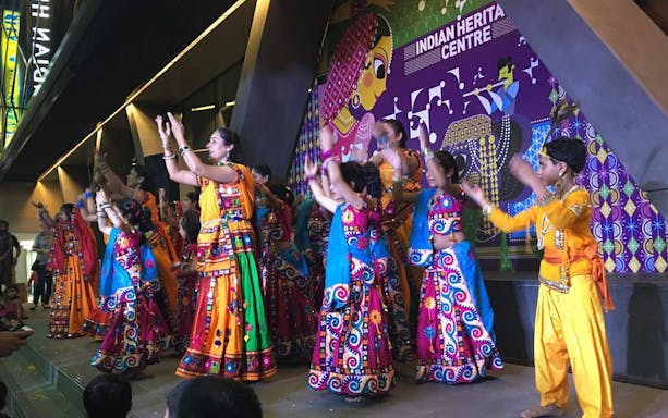 Traditional dance performance at Indian Heritage Centre, featuring colorful attire and cultural backdrop.