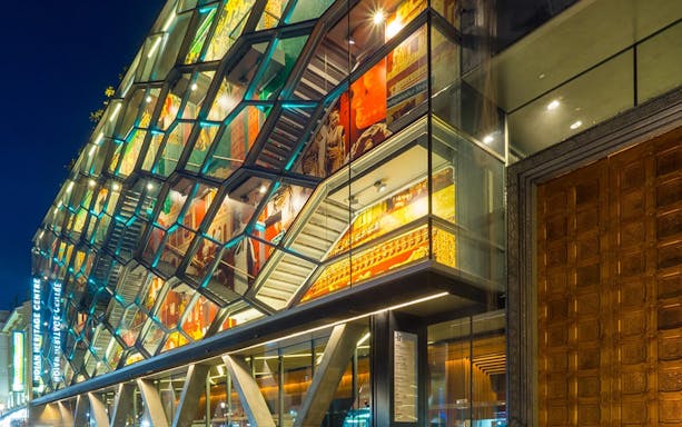 Indian Heritage Centre facade with colorful illuminated panels at night.