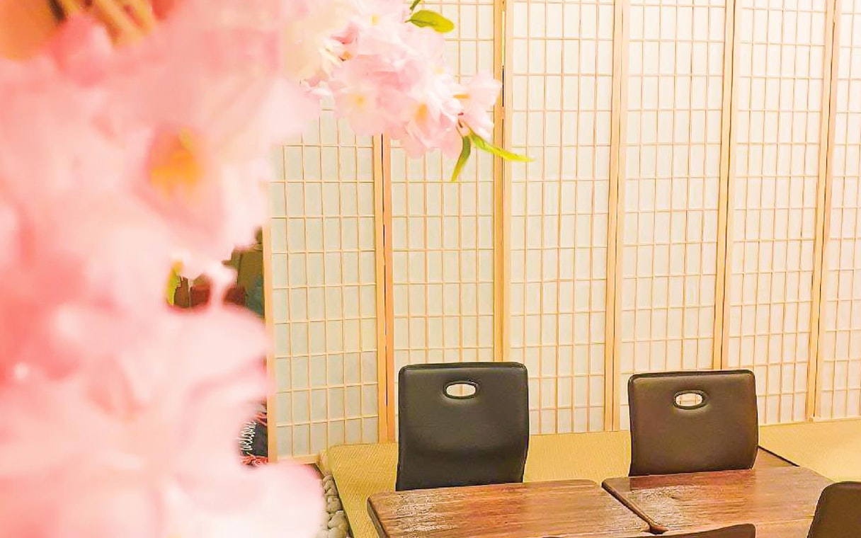 Seating area with wooden tables and chairs at Joya Onsen Cafe, Singapore.
