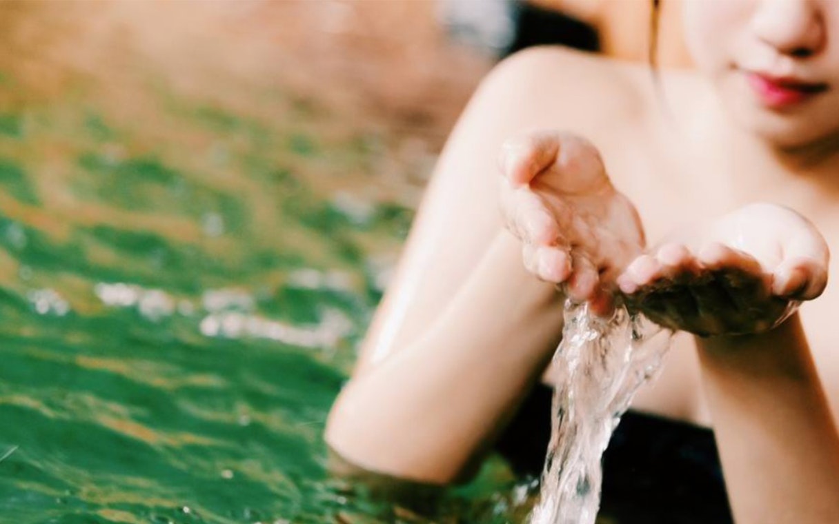 Person enjoying hot spring water at Joya Onsen Cafe, Singapore.