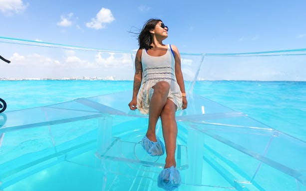 Tourists on a clear boat exploring Nichupte Lagoon in Cancun.