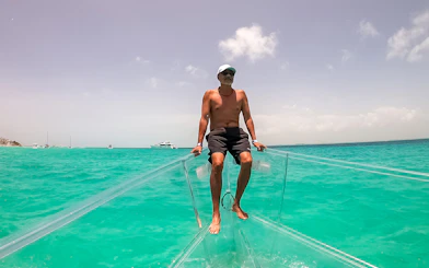 Man sitting on a clear boat in turquoise waters of Nichupte Lagoon, Cancun.