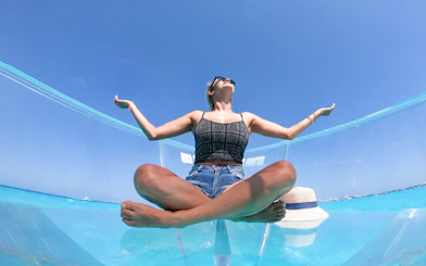 Person sitting on a clear boat at Nichupte Lagoon, enjoying the view of the blue water.