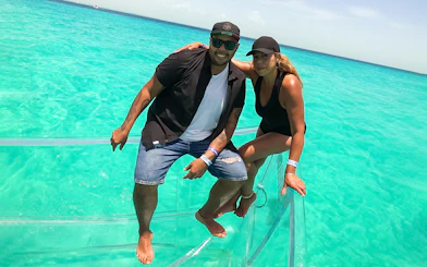 Couple enjoying a clear boat tour on Nichupte Lagoon's turquoise waters.