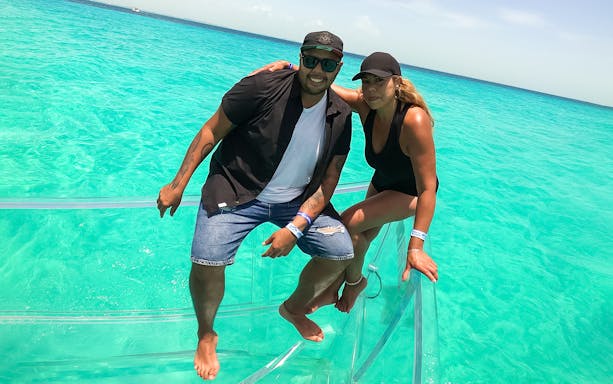 Tourists on a clear boat exploring Nichupte Lagoon in Cancun, Mexico.