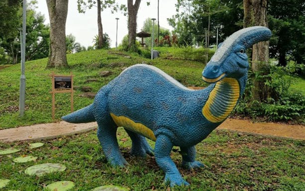 Dinosaur sculpture in a park setting at Island Wanderer.