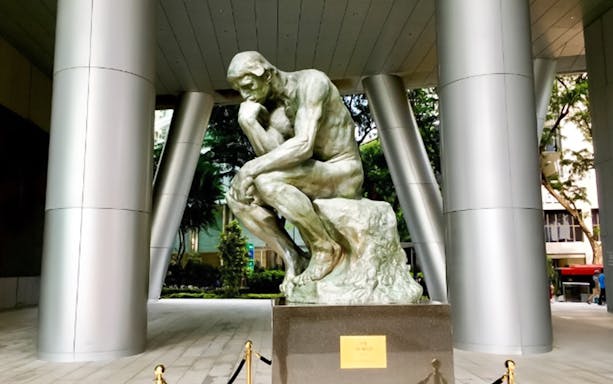 Statue of a thinker in a modern plaza, Island Wanderer tour location.
