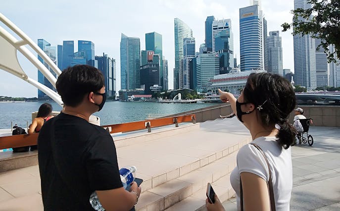 Tourists viewing Singapore skyline near Marina Bay Sands.