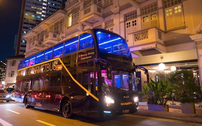Singapore GOURMETbus parked at night, offering Michelin Bib Gourmand Hawkers Fare dining experience.