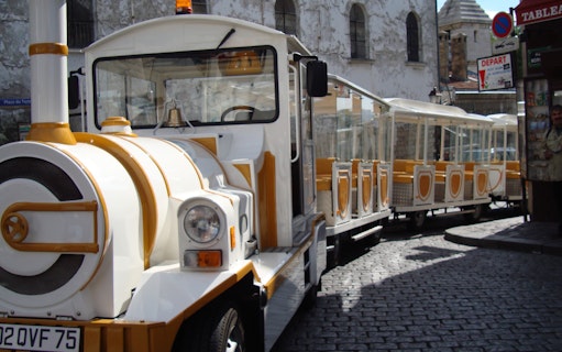 Tourist train on cobblestone street in Montmartre, Paris.