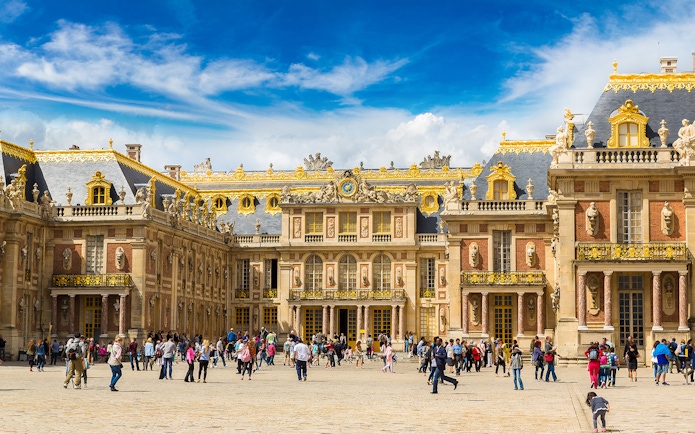 Palace of Versailles courtyard with tourists, part of The Paris Pass attractions.