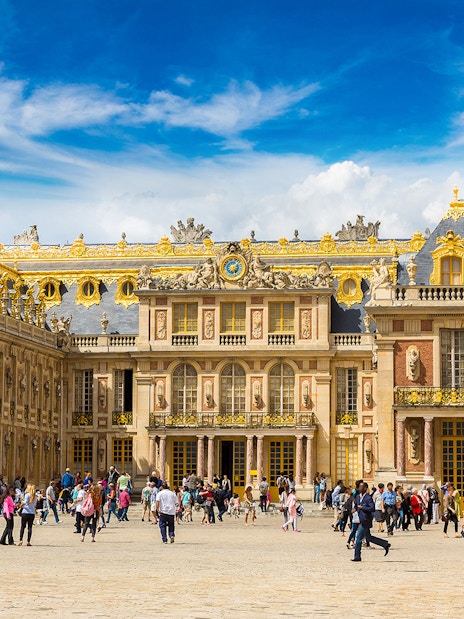 Palace of Versailles courtyard with tourists, part of The Paris Pass attractions.