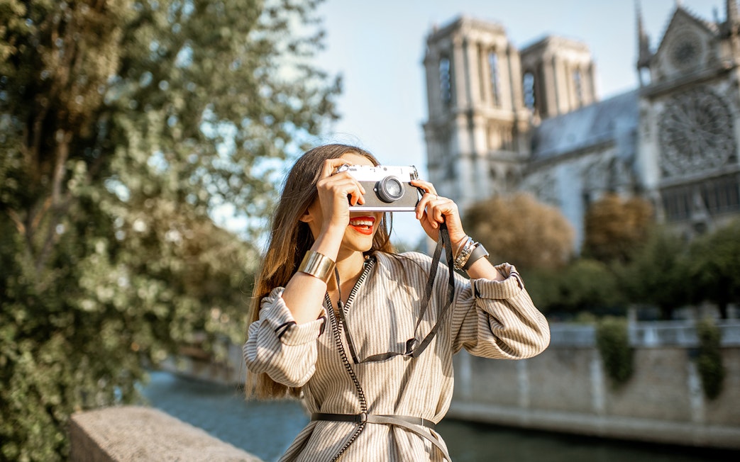 Tourist photographing Notre-Dame Cathedral in Paris.