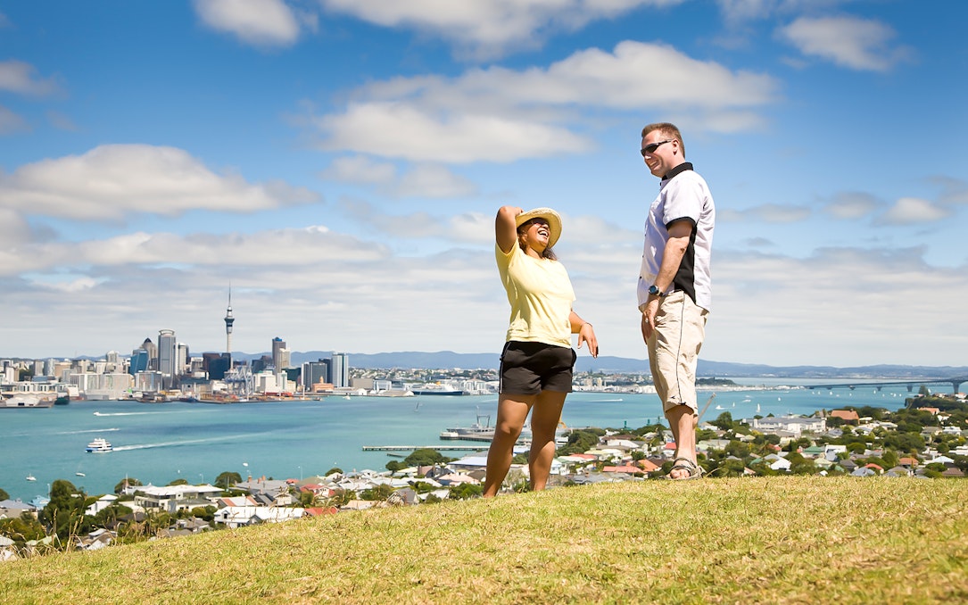 Couple enjoying a view of Auckland skyline and harbor on a luxury tour.