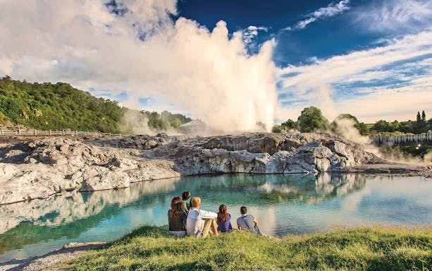 Visitors watching a geyser erupt at Te Puia geothermal park in Rotorua, New Zealand.