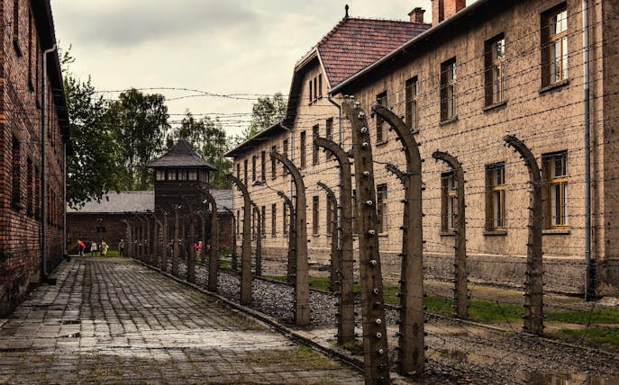 Auschwitz-Birkenau concentration camp buildings and barbed wire fences in Poland.