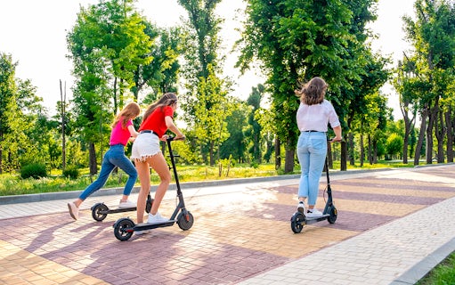 Scooter riders exploring a tree-lined path in Rome on an Imperial Tour.
