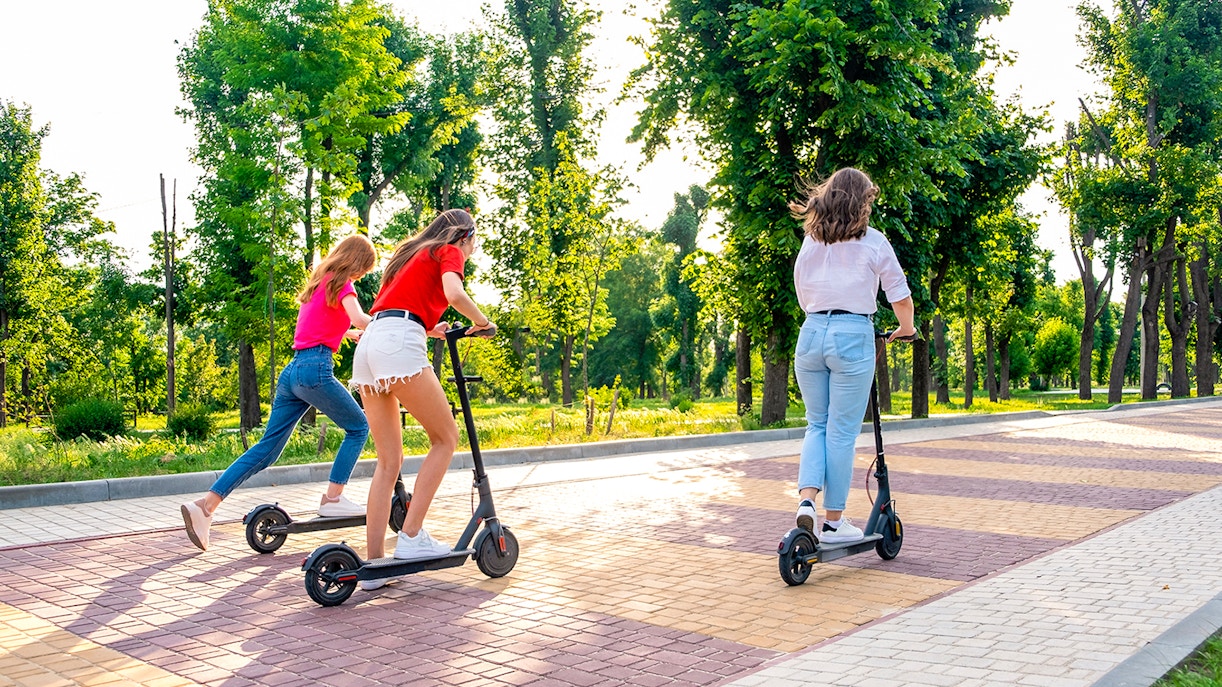 Scooter riders exploring a tree-lined path in Rome on an Imperial Tour.