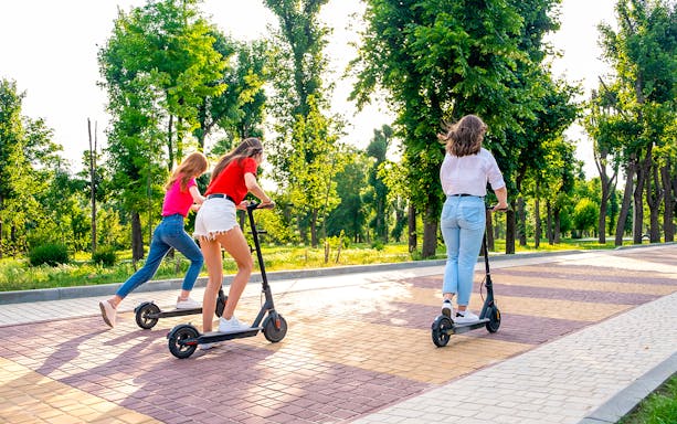 Scooter riders exploring a tree-lined path in Rome on an Imperial Tour.